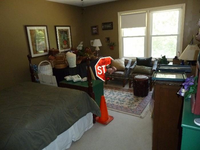 Stop sign, street sign, furniture, bed, chest of drawer and area rug