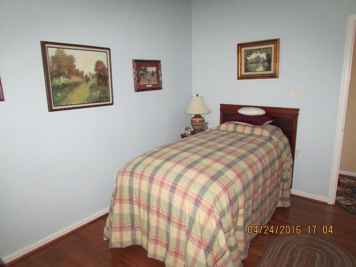 Twin bed shown among some of the hunt scene artwork