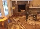 Rugs, iron glass top coffee table, elephants composition by fireplace