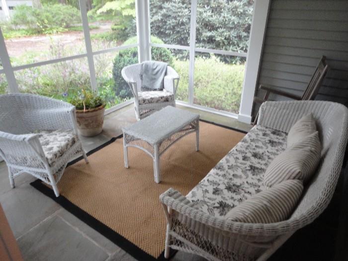 Wicker furniture set.  Set includes: sofa, stationary chair, rocking chair, and table.  Color: White.  Cushions included.