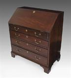 EARLY MAHOGANY SLANT FRONT DESK: Slant front opens to reveal central door, drawers and pigeon holes. 4 full length drawers with brass escutcheons and replacement brass pulls over bracket feet. 41" h. x 36" x 20".