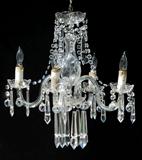 A PETITE CRYSTAL CHANDELIER: 4 light, crystal bent arms, garlands and extra ling prisms. Silver tone hardware. Measures approx. 21 1/4" h. x 18" dia., excluding the chain.