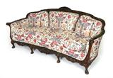 Lot 56:  LATE 19TH CENTURY PROFUSELY CARVED MAHOGANY SOFA: Ornate carved frame featuring shell, foliate, and floral motifs. 4 front legs end in hoof feet. Floral upholstery. 35 1/4'' h. x 80'' x 34''.
CONDITION: Wear consistent with age and use.