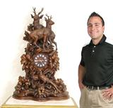 Lot 1: Monumental Black Forest Mantle Clock: Profusely carved w/ full figure doe and stag motifs, 41” h.