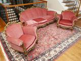 Lot 73: PINK MOHAIR PARLOR SET ON GILT FRAMES: Carved Rococo style gilt wood frames with mohair stuffed tacked pink upholstery and cushions. To include sofa 36 1/2'' h. x 82'' x 38'', 2 armchairs 33'' h. x 36 3/4'' x 33 1/2''.
CONDITION: Chips and loss of gilt decoration, chips at crests.