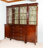 Lot 1013:  GEORGIAN MAHOGANY BREAKFRONT SECRETARY DESK: 3 section top architectural fretwork glass doors, center with 2 shelves, sides with 3 shelves. 3 section base, center section top drawer opens to secretary with leather writing surface, drawers and pigeon holes over 3 drawers. Side sections with 2 adjustable shelves. Overall measures 92'' h. x 88 1/2'' x 21''
CONDITION: Secretary missing one internal drawer, several old repairs, please call for condition.