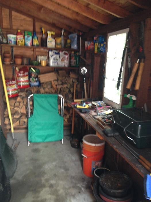 The woodshed has some Coleman camping items and lawn care tools and chemicals