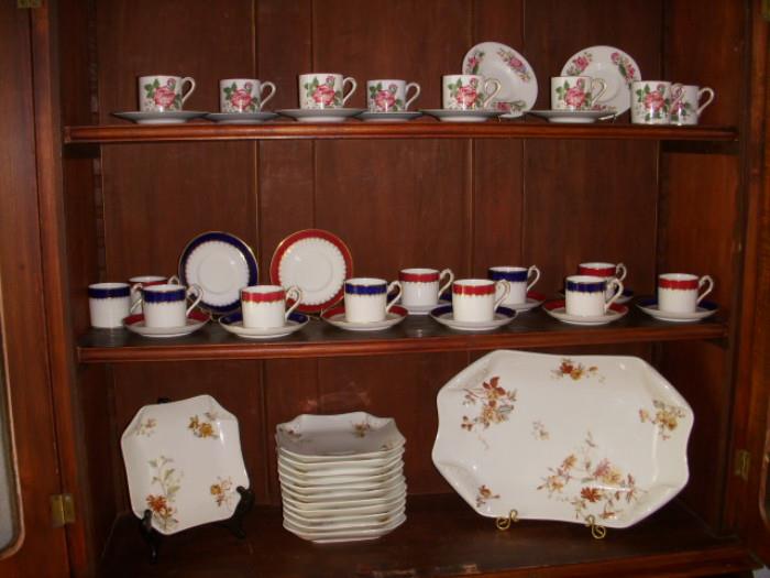 Demitasse cup sets (top is Wedgwood).  Bottom shelf: Haviland set
