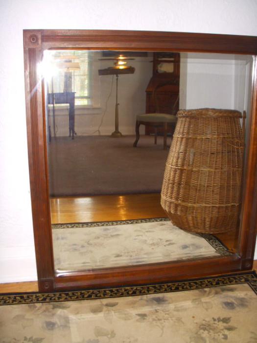 Beveled mirror reflecting large basket/hamper