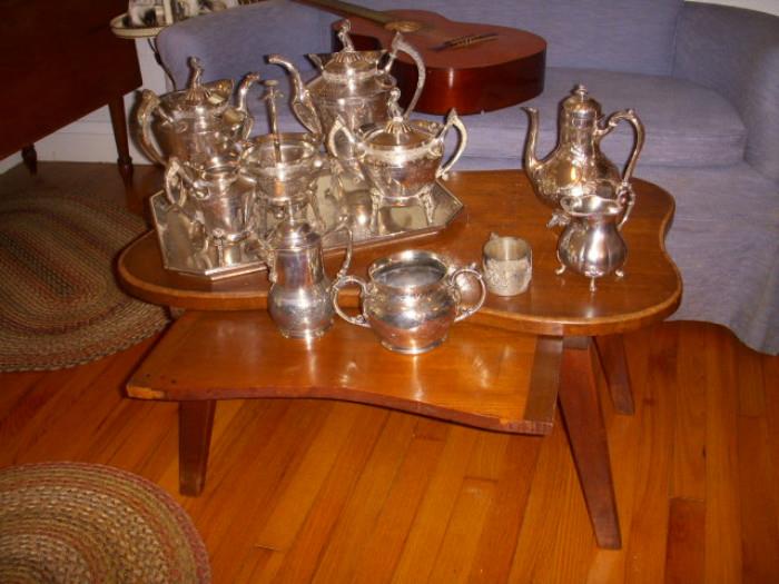 Walnut coffee table, biomorphic in shape, with pull-out surface.  Silverplate teaset, syrup pitcher, teapot, etc. 