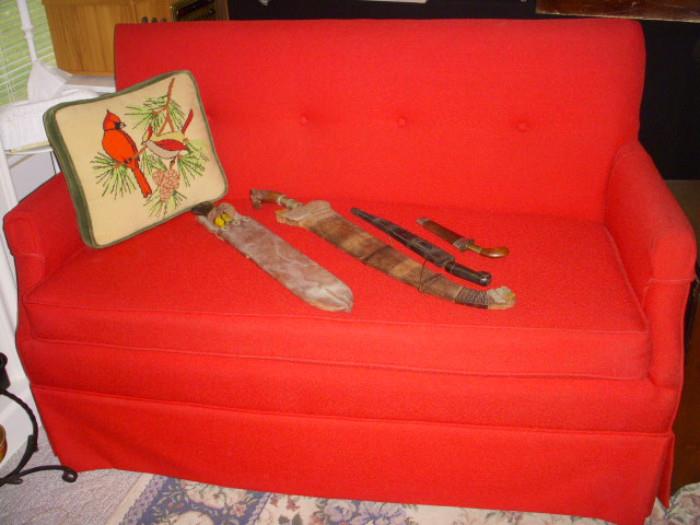 Red love seat displaying some Asian style knives
