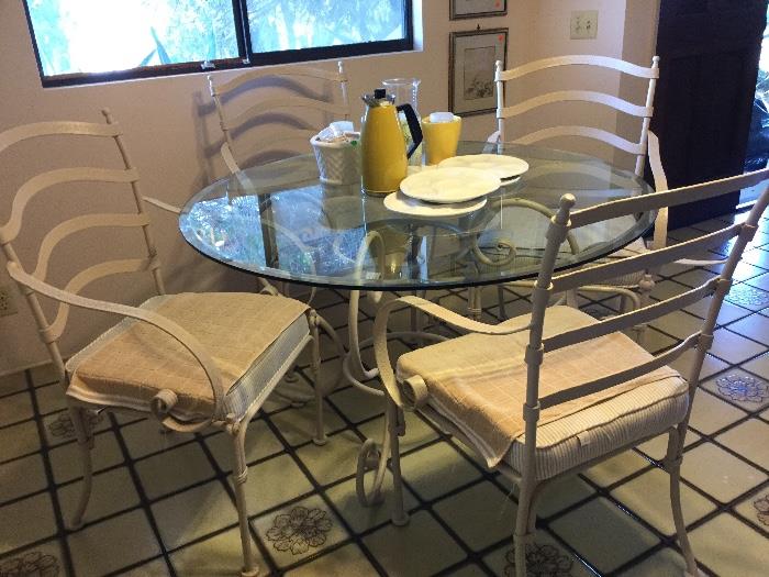 Iron patio or indoor table and 4 arm chair set, yet chairs tuck in around table nicely, need cushion recover, easy removal to customize- please zoom to see design on arms and backs of chairs, super high quality set