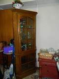 Small curio cabinet filled with glassware & small portable vacuum