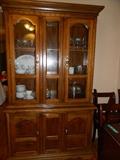 Duncan-Phyfe china cabinet filled with collectible glassware including glass cake plate. 