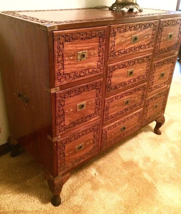 Side view of antique carved Asian chest