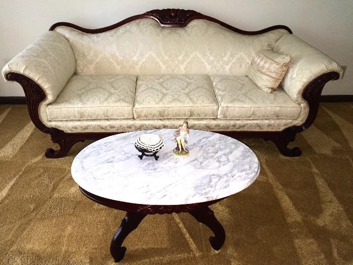 Victorian-style sofa with cream damask upholstery is in excellent, like-new condition. Also shown is the Victorian reproduction oval marble-top coffee table with carved detail at sides