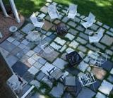 assortment of outdoor chairs, fire pit, wood rack, cement planters.