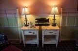 pair of twin bed frames with glass door knobs on top, pair of side tables with onyx tops, nautical lamps.