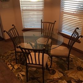 Glass top dining table with 4 chairs and Rug