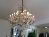 Pair of Rock Crystal Quartz Maria Theresa-style thirty-light Chandeliers - 18th/19th century - suspended crystal bead garlands and French-cut leaf pendants aboe a central faceted crystal sphere - now electrified.