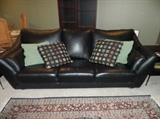 Contemporary leather sofa with throw pillows