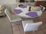 White and glass table with white leather chairs - notice the chrome legs