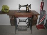 Singer sewing machines with foot pedal in cabinet + Oreck upright vacuum.