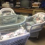 White wicker base with rectangular glass top; 6 white wicker chairs on rollers