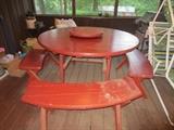 Round wood patio table with four benches and built-in lazy susan