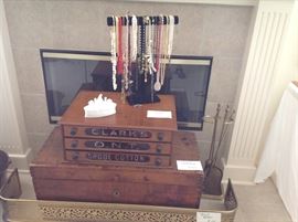  three drawer Clark spool cabinet has all its dividers, more jewelry and early wooden chest sit behind a decorative brass fender