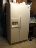 This side-by-side refrigerator is a whirlpool, has water and ice through the door and is in great shape.