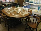 This dining table has leaves and 6 chairs. Notice the selection of glass on the table and some of the blue depression glass on the display behind it.