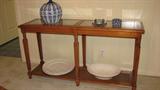This maple credenza table has glass insets in the top and a wooden lower shelf and has a clean-line style that would go with many different decors.