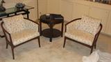 These barrel chairs feature dark mahogany wood and ivory and light blue upholstery.  They look very nice here, displayed with a Drexel drum table in similar wood and Asian-inspired detail at the leg.