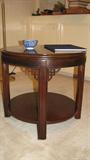 The close-up of the Drexel drum table shows the Asian detail at the legs and the well-kept finish of the wood.  This table is a companion piece to a set of other tables throughout the home and features an inlaid concentric circular pattern around the edge of the top.