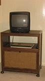 As per the style of a lot of the furniture in this home, this rolling television stand with storage compartment has an Asian feel, due to the wicker inset against the darker-stained wood.  I have to admit that I forgot to check on what the brand of the television is...