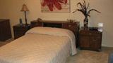 This Drexel bedroom set seems to be teak and includes the headboard with built-in storage, two nightstands, a 9-drawer mirrorless dresser with brass accents, and an octagonal end table with a glass inset in the top.  The bed here is a double, but it appears that the headboard can be configured to accomodate up to a king-sized bed.  The brass accents and shape of the furniture feature an Asian-inspired design.
