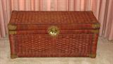 The medium-stained wicker trunk is about 12x28 inches and has brass accents.  It is the right size to be able to sit on the floor alone or could fit atop another surface, if you prefer.