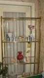 The brass and glass baker's rack has a feel of faux bamboo and could be used in a kitchen or, as it is here, as a display shelf in any part of the house.