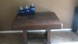 The low, sturdy table shows off a set of cobalt blue canisters.