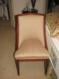 This handsome chair has creamy peach upholstery and a rather Asian feel in its stylized lines.
