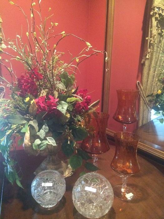 Floral arrangement, rose bowls, and graduated amber candle holders