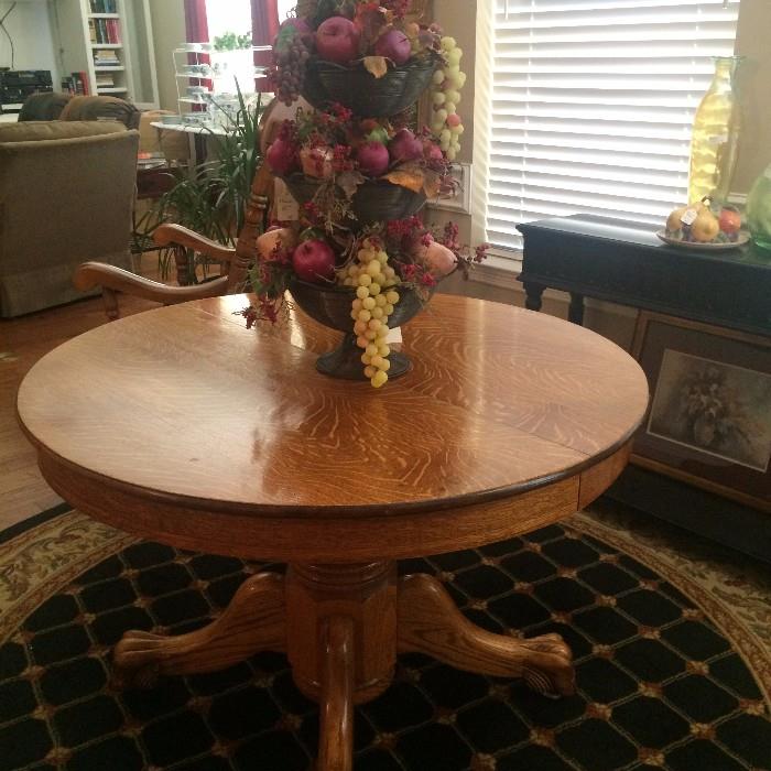 Antique oak table; tierred fruit arrangement; round rug