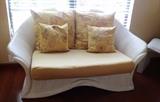 Matching sculpted rattan loveseat with throw pillows