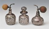 Three Silver Overlaid Perfume Bottles
Comprising two perfume bottles with atomizers and one with stopper, one engraved "Xmas 1898" and bearing mark of Alvin & Co. 5", 5 1/2" and 6" high  Bid at www.fairfieldauction.com through Wed. July 20th