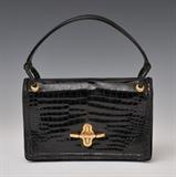Hermes Black Alligator Handbag
Single handle, monogrammed E.Q.C., brass clasp. Bag 6 1/2" x 9 3/4"; handle 13" long.  Bid at www.fairfieldauction.com today through Wed. July 20th