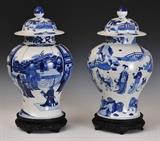 Two Chinese Blue and White Covered Temple Jars
with figural decoration, double-ring mark underneath, on carved wooden stands. 20" high overall x 10 3/4" diameter.  Bid at www.fairfieldauction.com today through Wed. July 20th