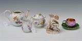 Assorted Meissen Porcelain Group
Comprising: Cherub Tailor, underside impressed 101 and scratch-marked 0 16, 5" high, 4 1/4" long, 3 1/2" deep; a lotus cup and saucer cup with gilt interior, a together with a teapot a similar cream pitcher and an associated covered sugar bowl. Lotus cup 3 3/4" across handle; saucer 5" diameter; teapot 7 1/4" across spout and handle..  Bid at www.fairfieldauction.com today through Wed. July 20th