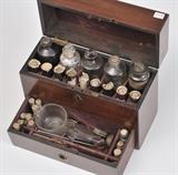 Traveling Mahogany Apothecary Case
19th Century With bottles, flasks, mixing bowl and scales. Case 9" high, 11 1/2" wide, 4 3/4" deep.  Bid at www.fairfieldauction.com today through Wed. July 20th