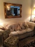 Cream sofa with separate cushions, highly carved in gold frame beveled oblong mirror, the Americana vinyl upholstered vintage chair